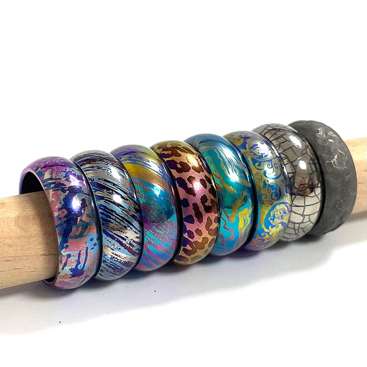 Anodized Titanium Band Ring: assorted patterned band rings arranged on a rod (gallery view 05).
