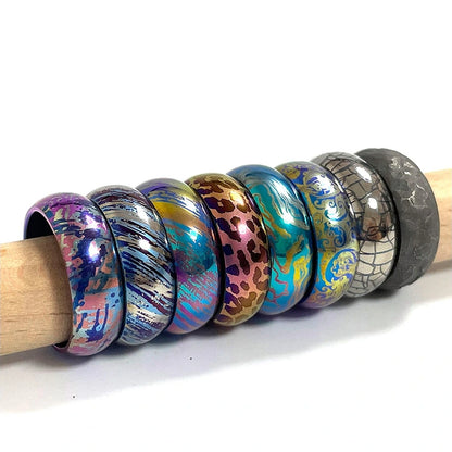 Anodized Titanium Band Ring: assorted patterned band rings arranged on a rod (gallery view 05).