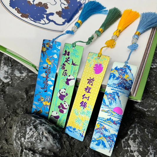 Titanium Tassel Bookmark: assorted illustrated bookmarks and tassels beside a book (gallery view 01).
