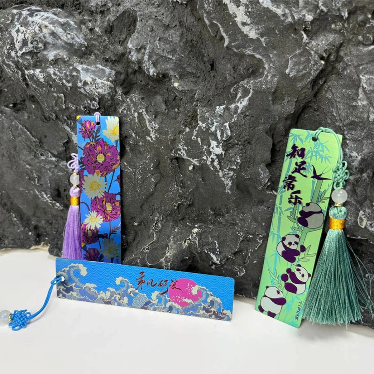 Titanium Tassel Bookmark: floral and panda bookmarks beside a blue design (gallery view 03).