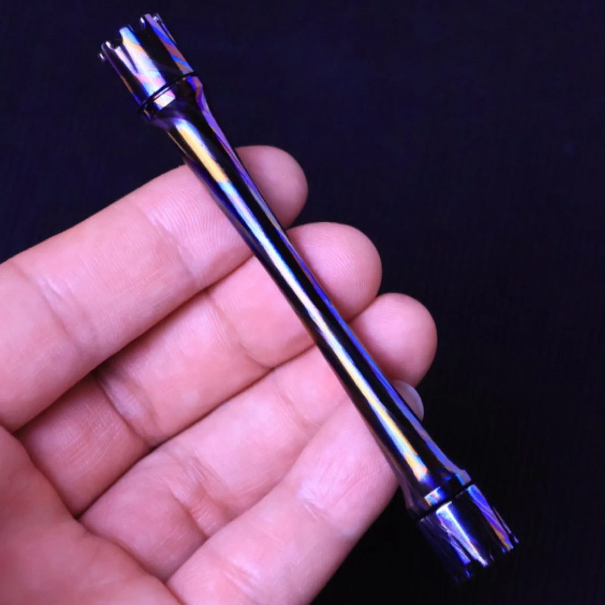 Dark metal Chimago spinner rod displayed on a desk