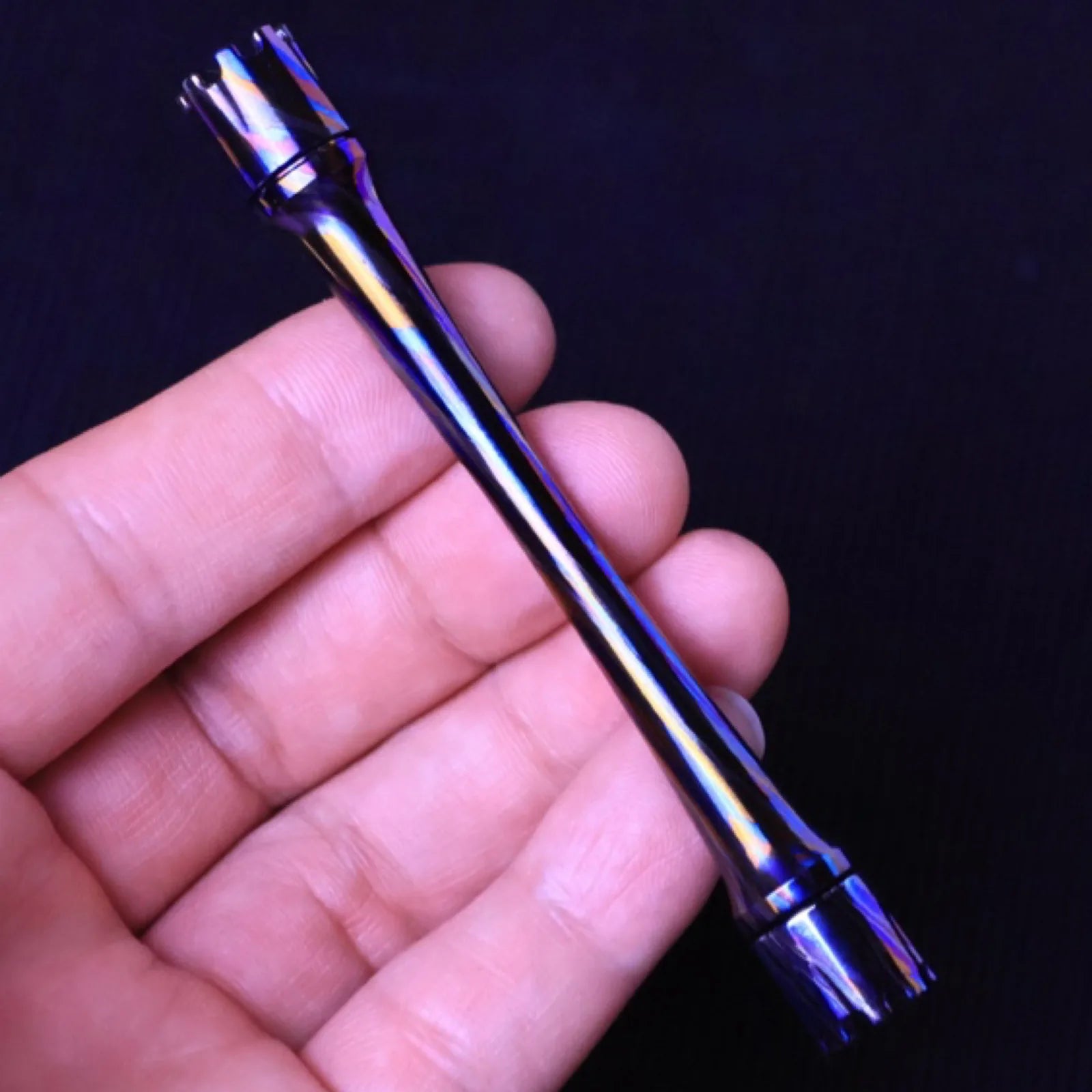 Dark metal Chimago spinner rod displayed on a desk