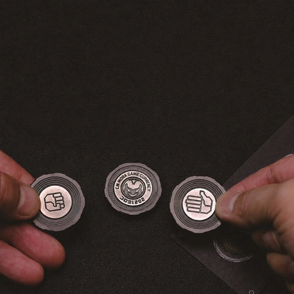 Three Chimago decision coins held for rock paper scissors play