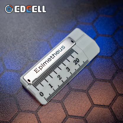 White EDCCELL ruler-style mechanical slider on a dark hex-pattern surface