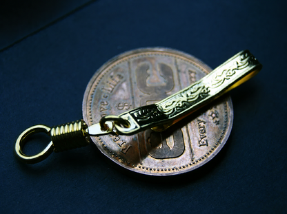 Gold-tone scroll-patterned EDC pocket clip with coiled connector and ring; display coin not included