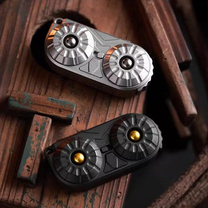 Owl-Face Stainless Steel Fidget Slider: natural and black owl faces compared on wood (gallery view 01).