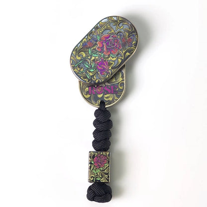 Rose Swirl Titanium Rotary Fidget Slider: rose slider rotated open above braided lanyard (gallery view 04).