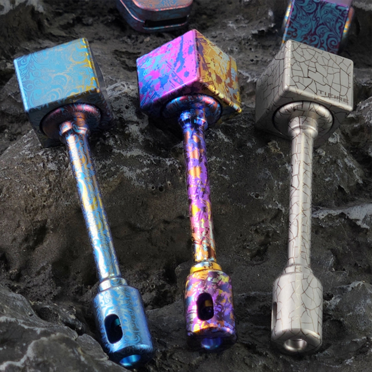 Square Titanium Fidget Spinner: three complete patterned handle assemblies on stone (gallery view 02).