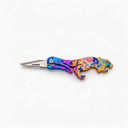 Animal-Shaped Titanium Folding Knife & Bottle Opener: splatter handle with blade extended on white (gallery view 05).