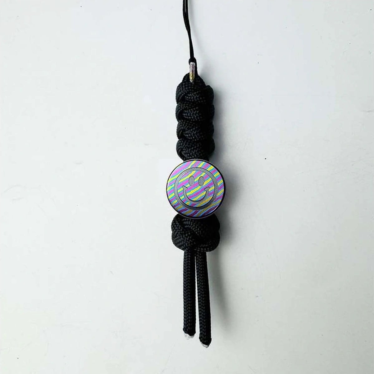 Smiley Face Titanium Lanyard Bead: complete black woven cord configuration on white (gallery view 06).