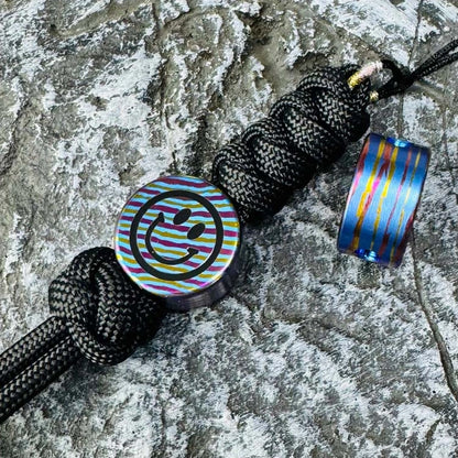 Smiley Face Titanium Lanyard Bead: front and side views on black braided lanyards (gallery view 04).
