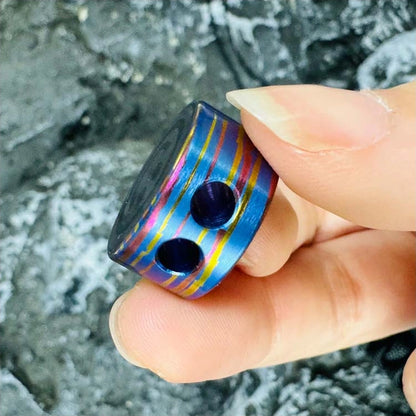 Smiley Face Titanium Lanyard Bead: hand-held side view showing two cord openings (gallery view 02).
