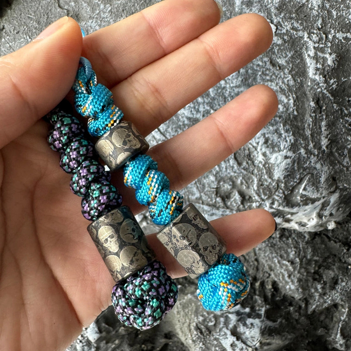 Dark Skull Titanium Lanyard Beads: hand holding two skull bead lanyards (gallery view 02).