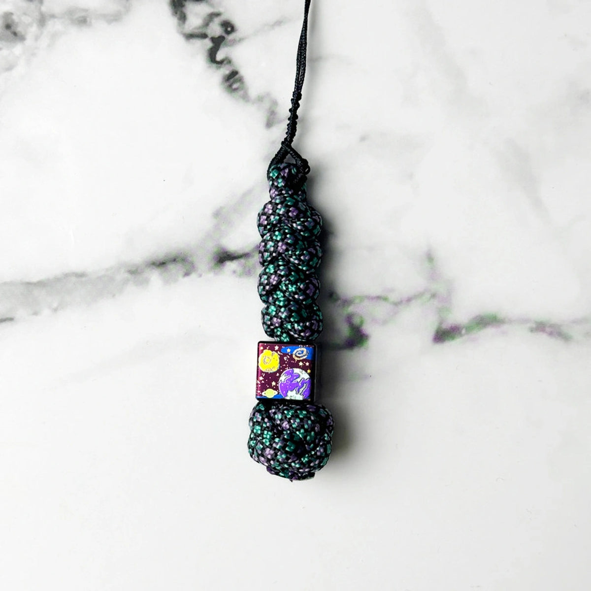 Planet Artwork Titanium Lanyard Beads: small square bead on dark patterned cord (gallery view 12).