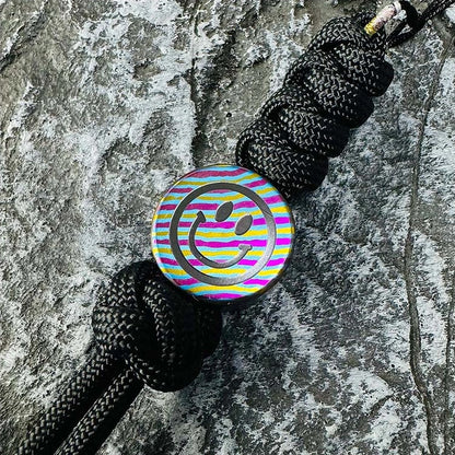 Smiley Face Titanium Lanyard Bead: smiley face bead threaded onto black braided cord (gallery view 01).