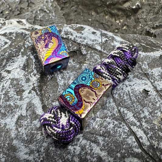 Mechanical Snake Titanium Lanyard Bead: snake artwork bead beside purple braided cord (gallery view 01).