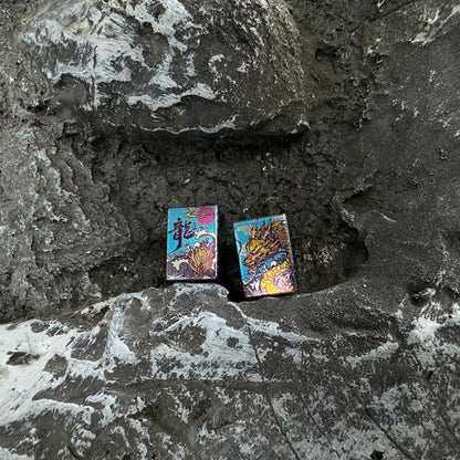 Wave Dragon Titanium Lanyard Bead: two illustrated bead faces resting on stone (gallery view 02).