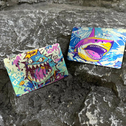 Illustrated Titanium Morale Patch: two shark artwork patches resting on stone (gallery view 02).
