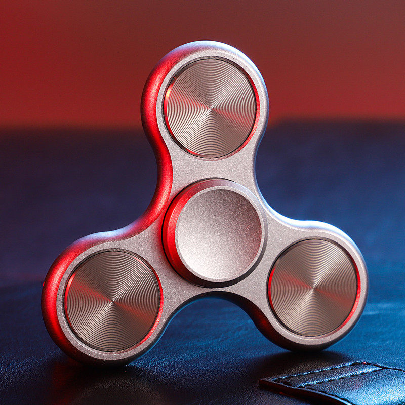 Silver-tone three-lobe spinner with three circular grooved inlays and a round central grip.