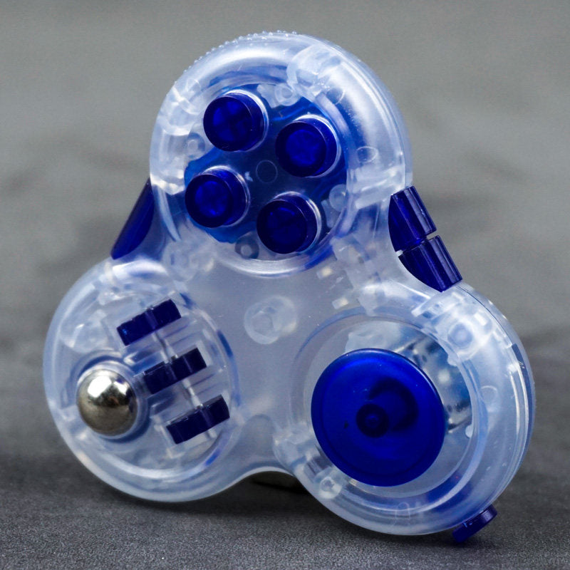 Clear three-lobed triangular fidget toy with blue buttons, a joystick and three wheels beside a metal-colored ball.