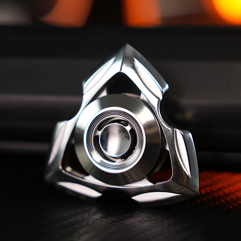 Polished stainless-steel Siren spinner with a sculpted triangular frame and circular center grip.