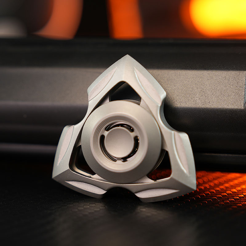 Matte stainless-steel Siren spinner with a sculpted triangular frame and circular center grip.