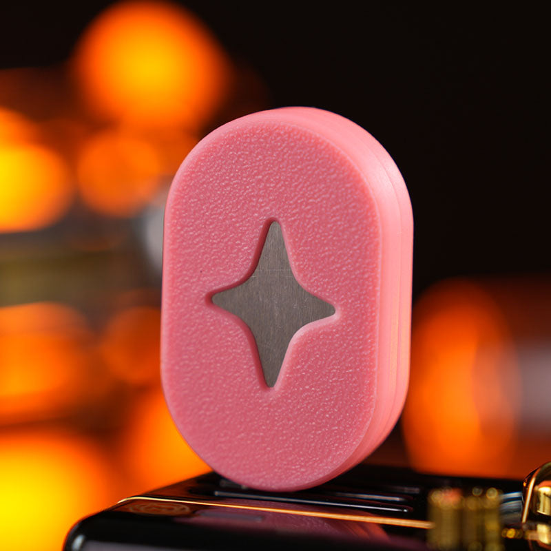 Polar Star / Cherry Blossom Pink fidget slider with a textured pill-shaped face and a four-point star motif.