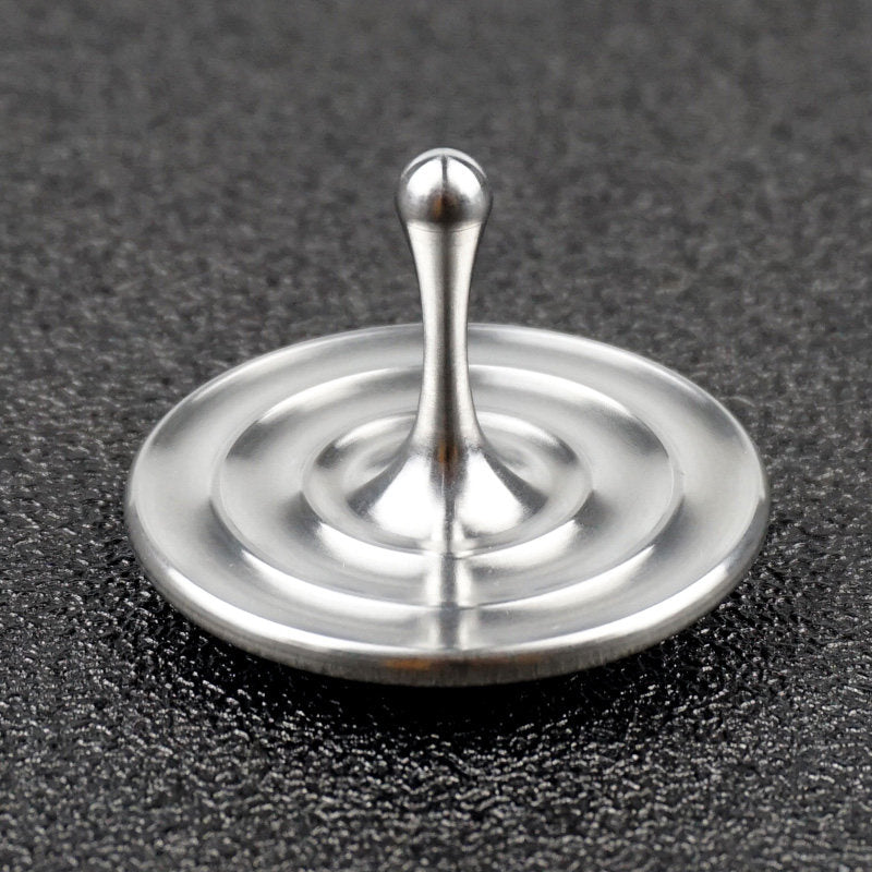 Water-drop spinning top on dark fabric
