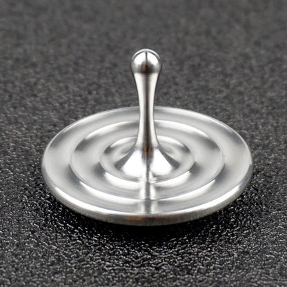 Water-drop spinning top on dark fabric