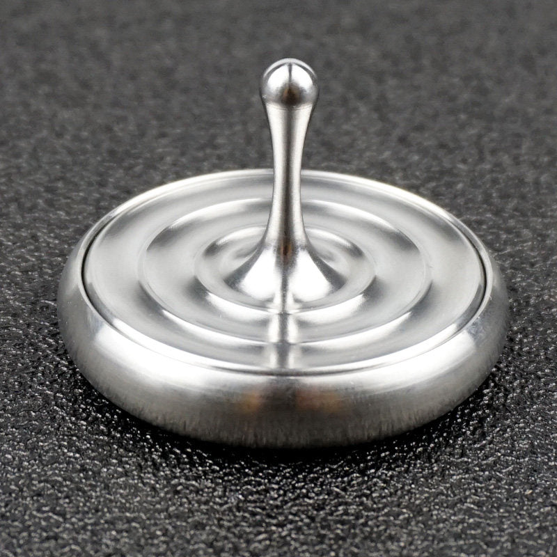 Water-drop spinning top and matching base in an angled view