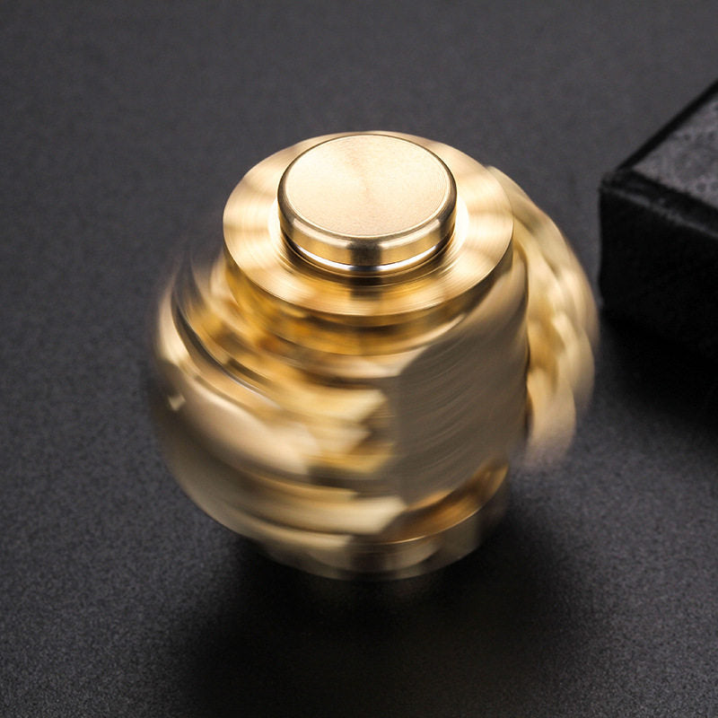 Copper-tone linked-gear fidget cube shown spinning on dark fabric