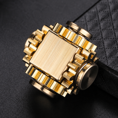 Copper-tone linked-gear fidget cube close-up on dark fabric