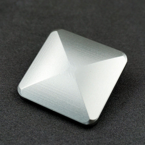Silver-tone faceted desktop flip toy on dark fabric