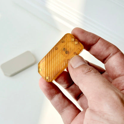 An amber WMEDC 20TH PEI slider held in one hand