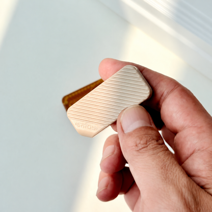A light-colored WMEDC 20TH PEEK slider held between the fingers